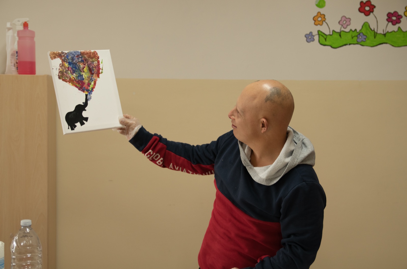 Un ospite del centro diurno mostra il suo quadro