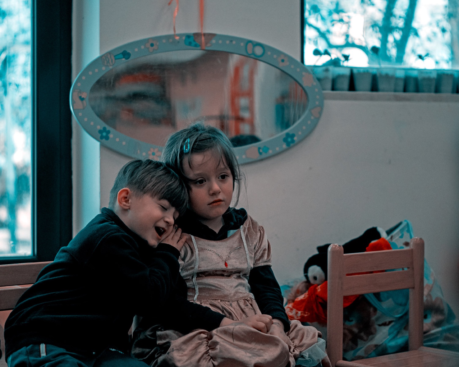 Due bambini giocano davanti allo specchio