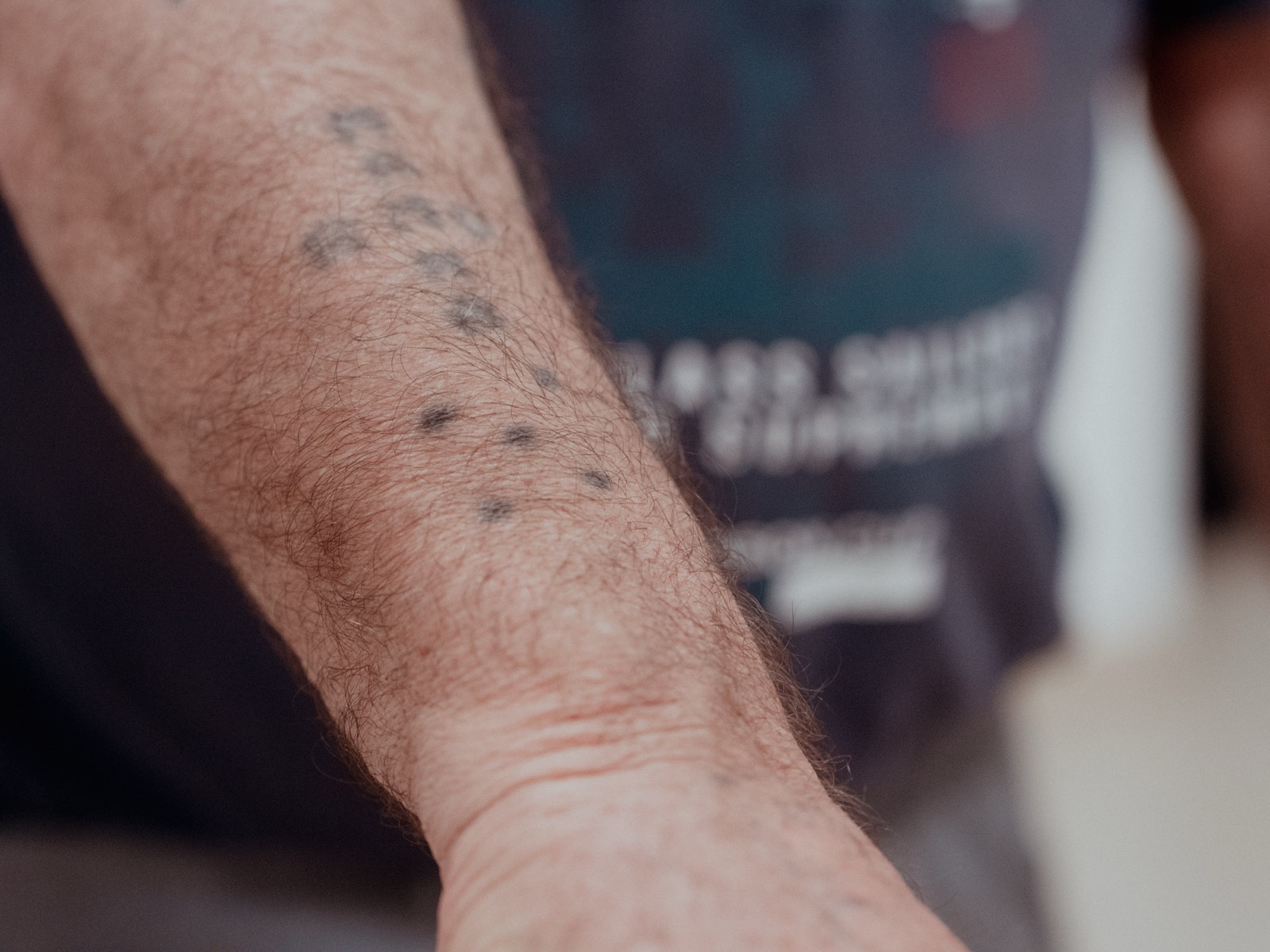 L’avambraccio tatuato di Cesare, in primo piano
