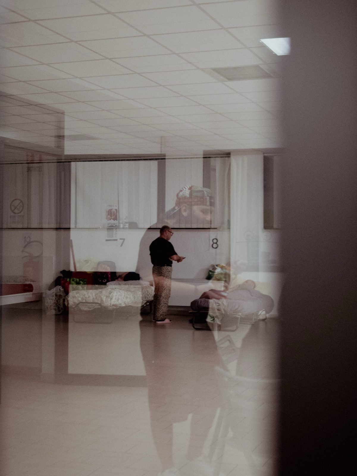 Lo stanzone del dormitorio visto attraverso il riflesso di una porta-finestra