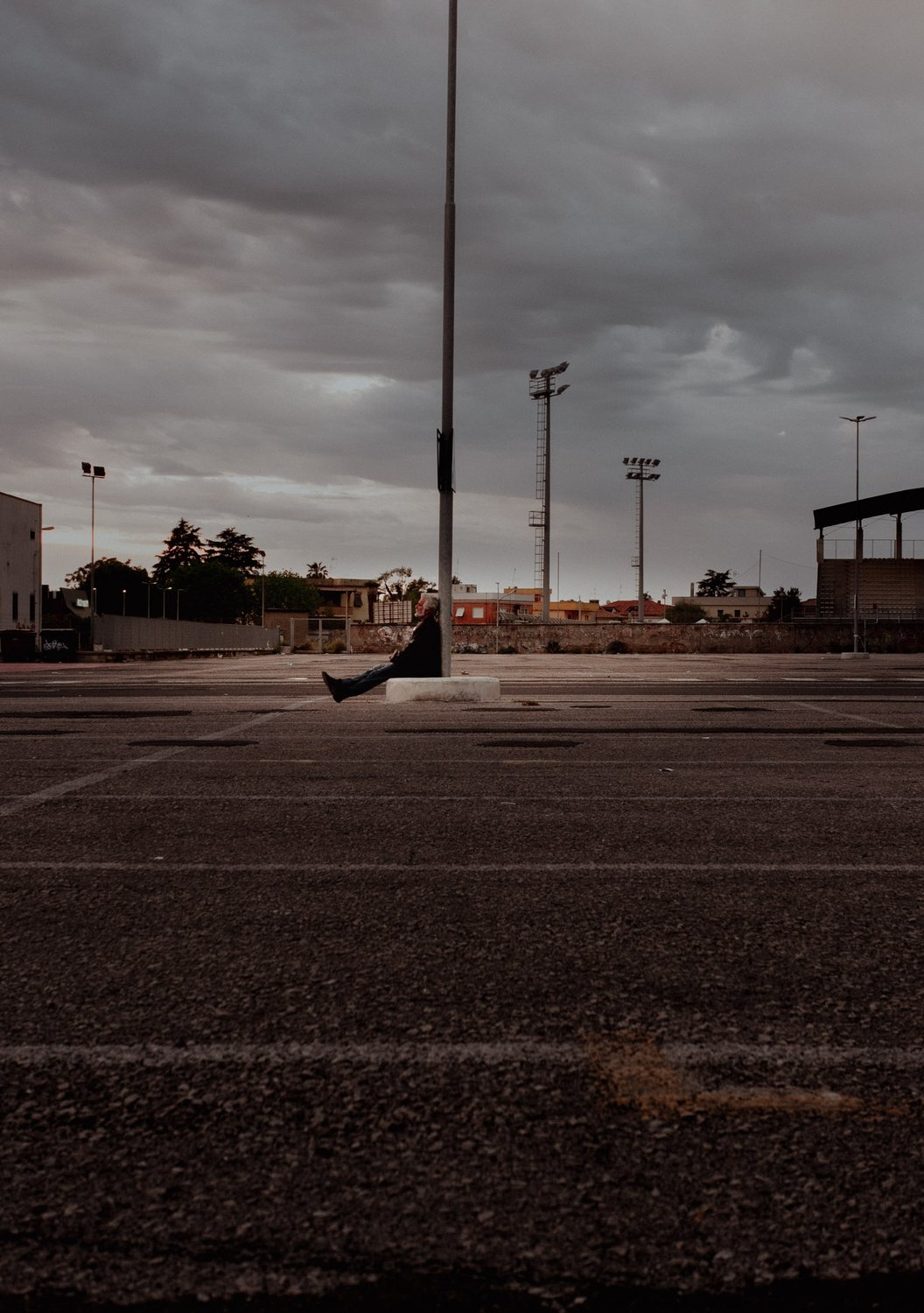 Il piazzale deserto davanti al dormitorio, con il campo sportivo sullo sfondo